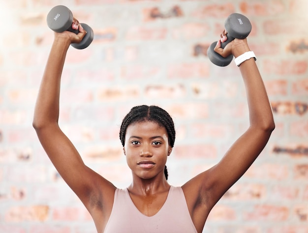 Halteres de treinamento de força e mulher negra em exercícios de saúde de ginástica e motivação para objetivo corporal Forte poder e retrato de um atleta africano com pesos para cardio e perder peso