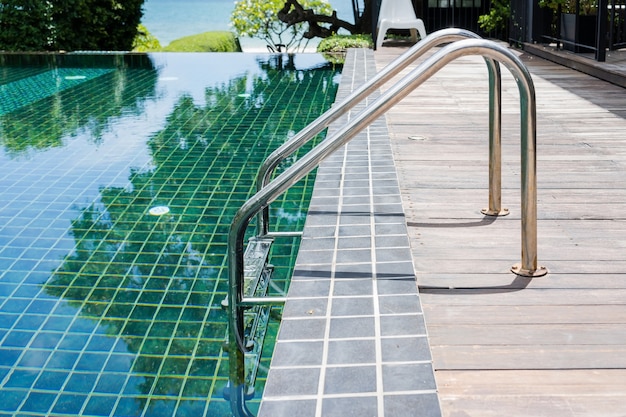 Haltestangenleiter im blauen Swimmingpool