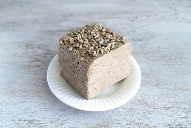 Halva aus Sonnenblumenkernen auf einem weißen Teller nationale traditionelle Süße der türkischen Halva auf dem Tisch Foto in hoher Qualität