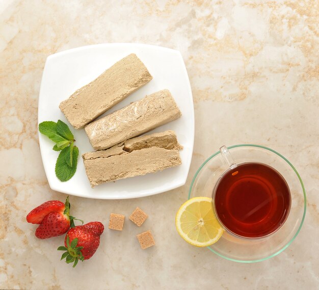 Halva en un plato blanco con té de limón y fresas