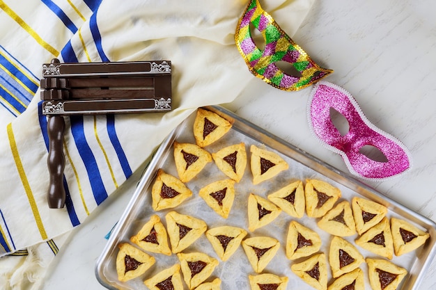 Hamantaschen jüdische Kekse auf Backblech mit Maske für Purim.