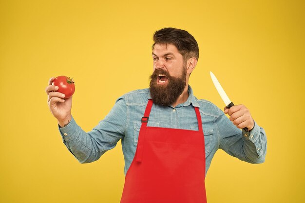 Hambriento por qué esperar Hambriento hipster corte tomate con cuchillo Sufrimiento de hambre Dieta saludable y dieta Cocinar comida vegetariana Receta vegetal Chef cocinó comida fresca Apresurado y sabroso