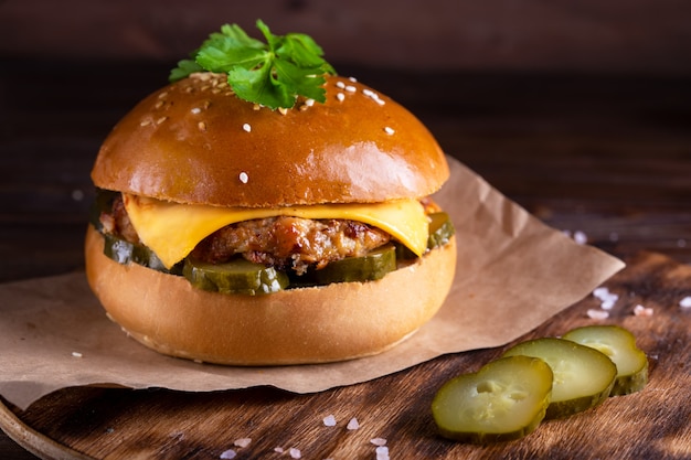 Hamburger caseiro com carne e pepinos na madeira