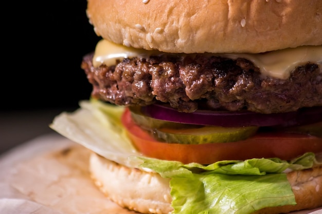 Hamburger Closeup auf schwarzem Hintergrund frisches Gemüse und gegrilltes Fleisch