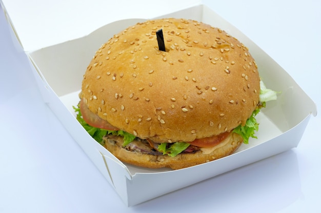 Hamburger mit Fleisch, Salat und Tomaten in einem Karton.