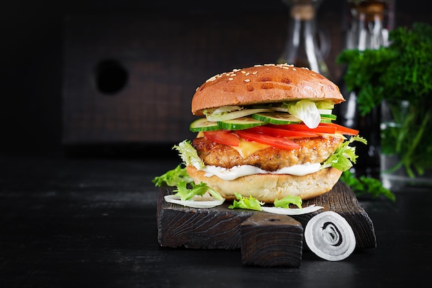 Hamburger mit hühnchen burger fleisch käse tomaten gurke und salat auf holzhintergrund leckerer burger nahaufnahme