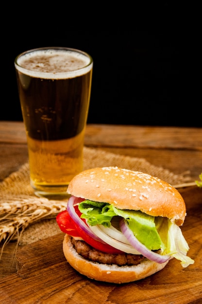 Foto hamburger mit krug bier auf holztisch