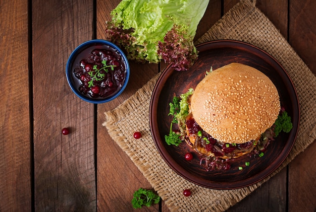 Hamburger mit saftigem Putenburger mit Käse, karamellisierten Zwiebeln und Preiselbeersauce. Draufsicht