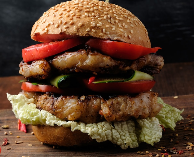 Hamburger mit Schweinefleisch briet Steak und rote Tomaten