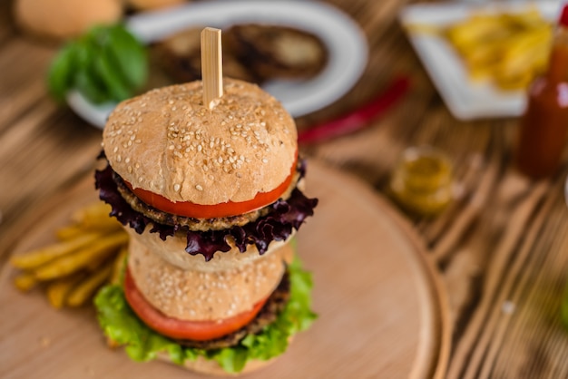 Hamburger saboroso com carne e vegetais contra um fundo escuro. Comida rápida. Pode ser usado como pano de fundo