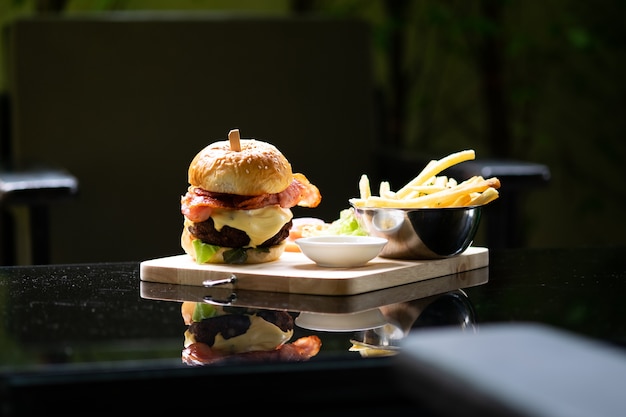 Hamburger und Pommes auf dem hölzernen Tablett.