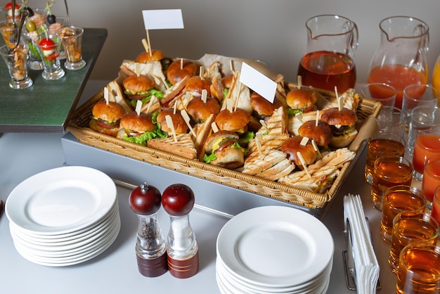 Hamburger und Sandwiches in einem großen Catering-Korb Schön gedeckter Tisch