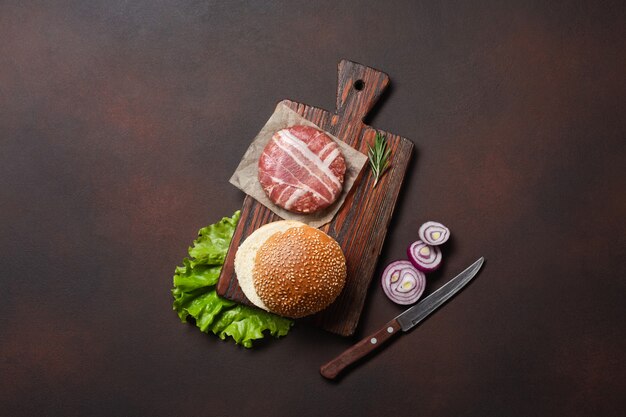 Hamburger Zutaten rohes Schnitzel, Tomaten, Salat, Brötchen, Käse, Gurken und Zwiebeln