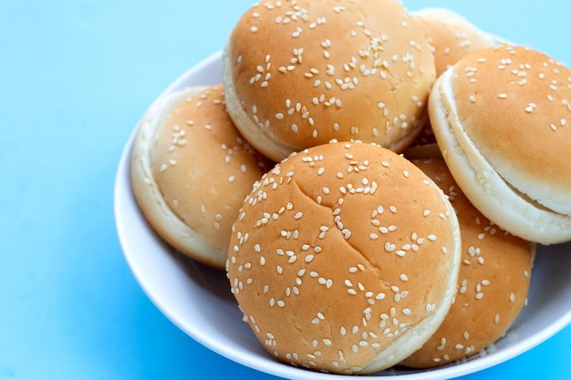 Hamburgerbrötchen mit Sesam auf blauem Hintergrund