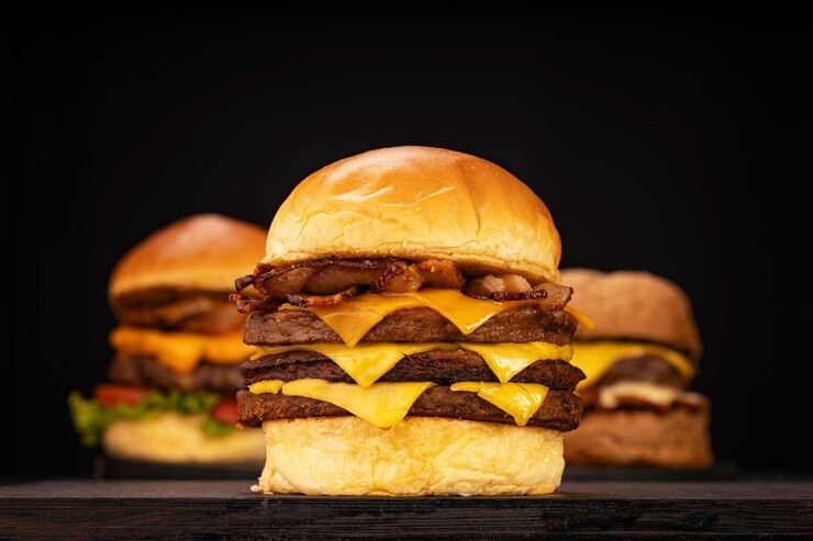 Foto hambúrguer acompanhado de batatas fritas e refrigerante em uma foto de estúdio com madeira marrom e preta