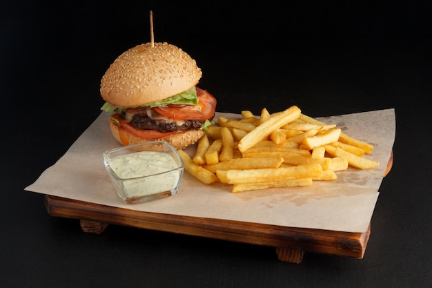 hambúrguer apetitoso em uma placa com fundo escuro