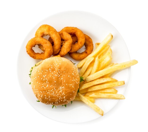 Hambúrguer, batatas fritas e anéis de cebola em um prato branco. vista do topo