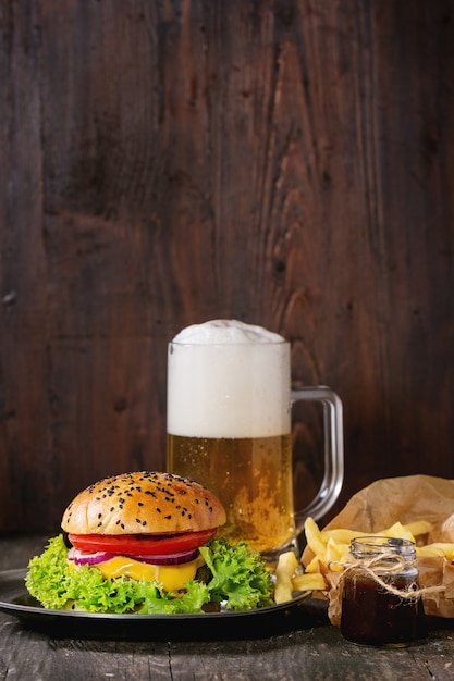 Foto hambúrguer caseiro com cerveja e batatas