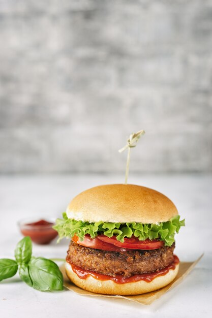 Hamburguer caseiro do vegetariano na superfície rústica branca