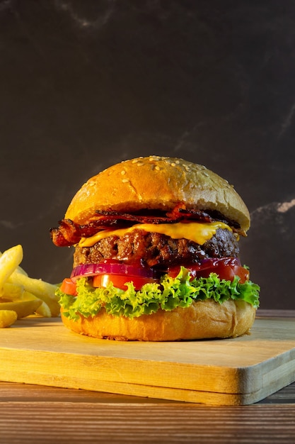 Hambúrguer com batata frita em uma tábua de madeira