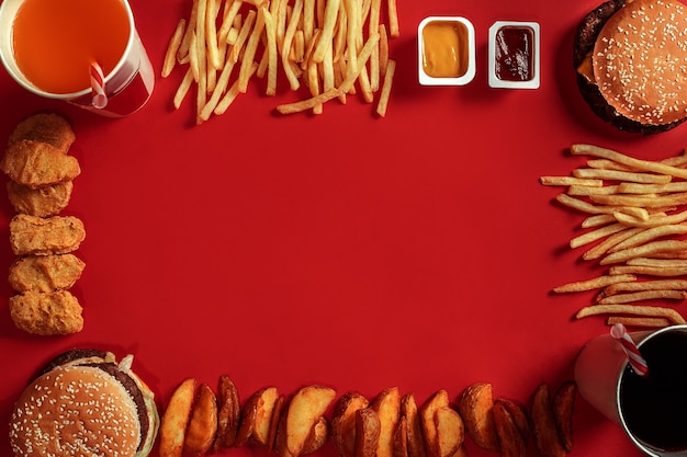 Foto hambúrguer com batatas fritas hambúrguer e batatas fritas em caixa de papel vermelha fast food sobre fundo vermelho