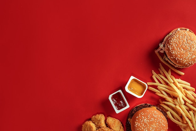 Hambúrguer com batatas fritas hambúrguer e batatas fritas em caixa de papel vermelha fast food sobre fundo vermelho