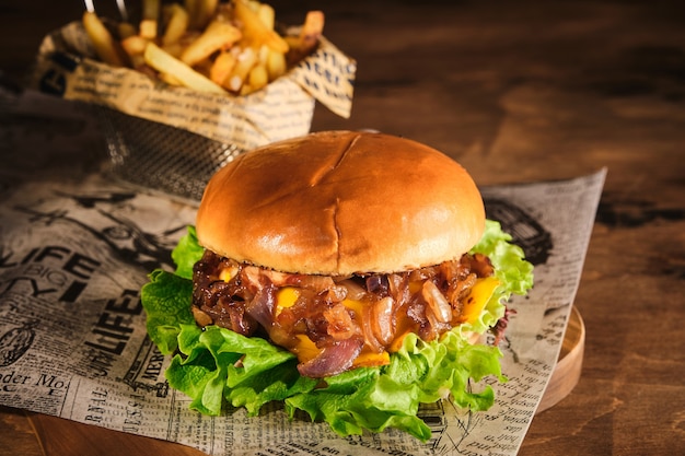 Hambúrguer com carne e cebola caramelizada em uma placa de madeira. cheeseburger com cebola e carne. suculento hambúrguer caseiro delicioso.