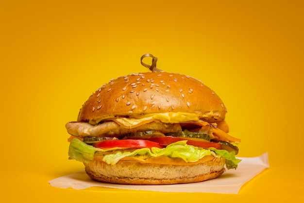 hambúrguer com hambúrguer de carne e queijo cheddar em um fundo amarelo