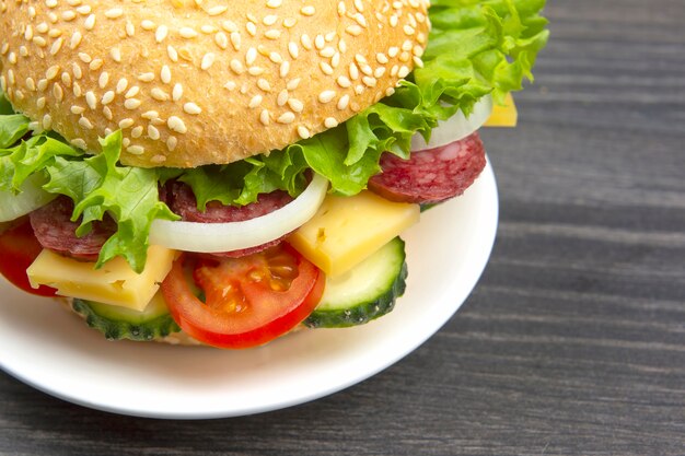 Hambúrguer com legumes e salsicha. Fast food e café da manhã. Calorias e dieta.