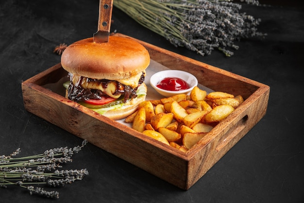 Hambúrguer de carne bovina com batata frita e ketchup na tábua de madeira