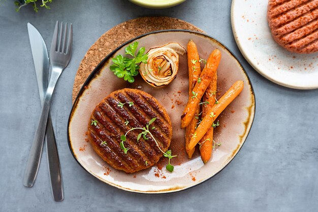 Hambúrguer de carne falsa vegano grelhado com cenouras em um prato almoço saudável sem carne