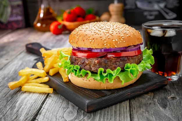 Hambúrguer de carne grelhada com tomate cebola e batatas fritas