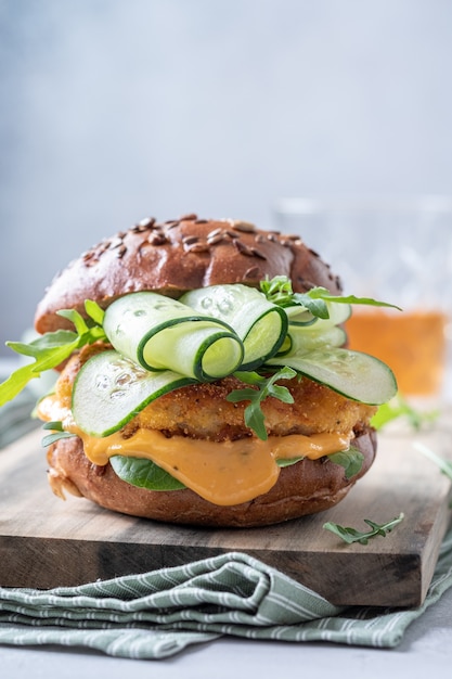 Hambúrguer de peixe com pepino em uma placa de corte