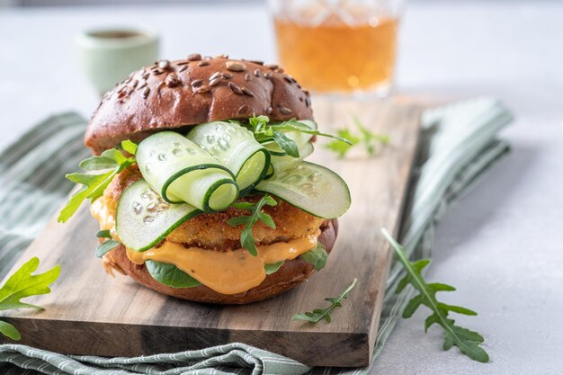 Hambúrguer de peixe com rúcula e molho de pepino