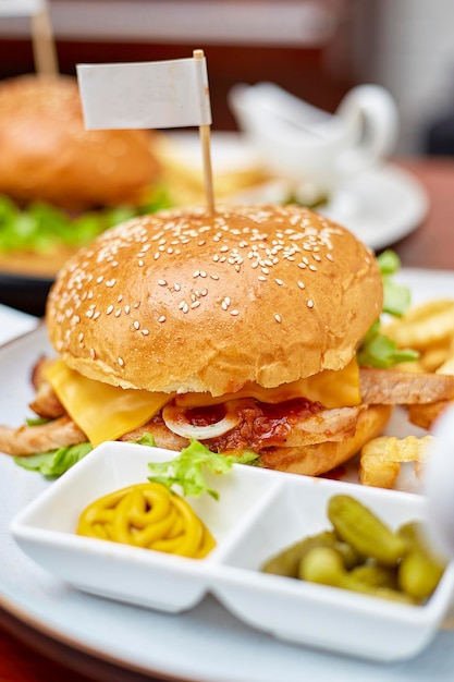 Hambúrguer de porco picante grelhado com queijo cheddar servido em pl branco