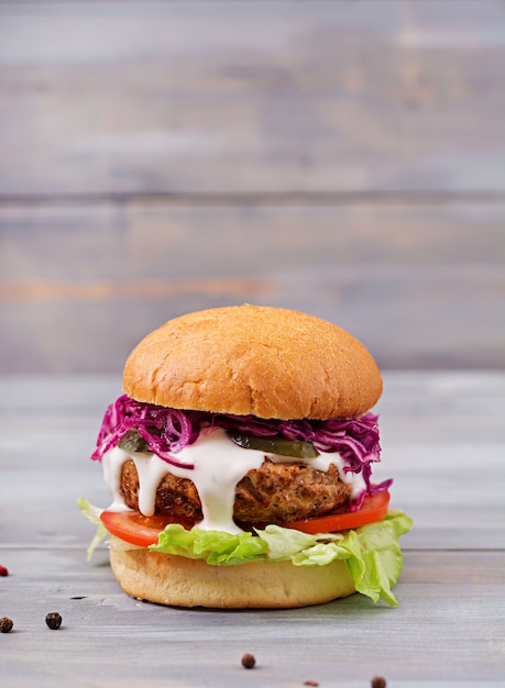 Hambúrguer de sanduíche com hambúrgueres suculentos, tomate e repolho roxo