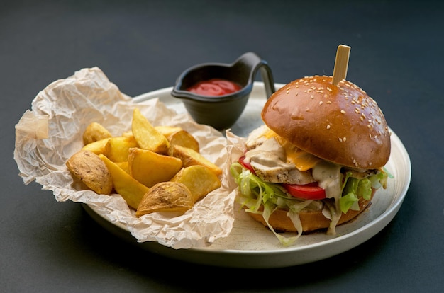 Hambúrguer delicioso, hambúrguer servido com batatas fritas em um fundo preto