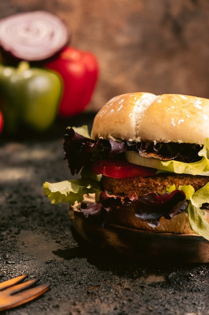 Hamburguer do vegetariano de seitan na superfície de madeira com vegetais. comida vegan saudável