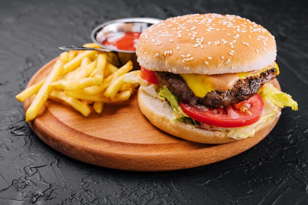 Hambúrguer fresco com batatas fritas na madeira