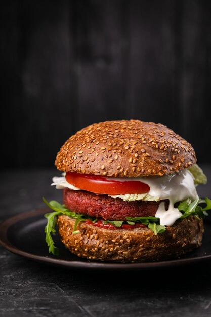 Hambúrguer fresco com carne e vegetais veganos, polvilhado com sementes de gergelim