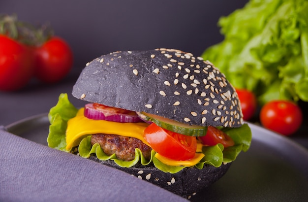 Hambúrguer preto caseiro com costeleta e legumes no guardanapo