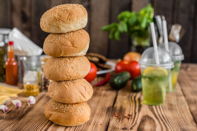 Hambúrguer saboroso com carne e legumes contra um fundo escuro