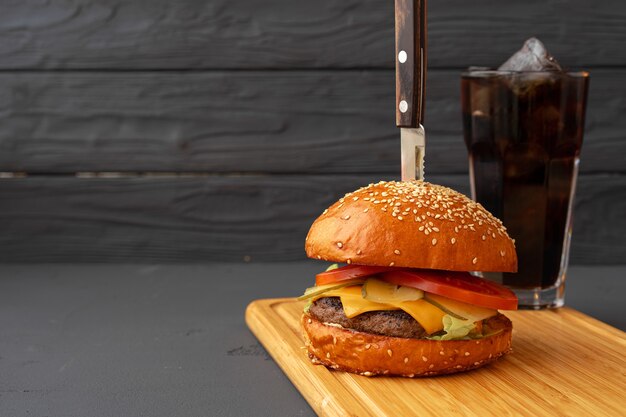 Hambúrguer saboroso em fundo preto de madeira close-up foto