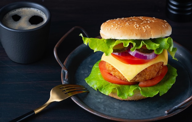 Hambúrguer saboroso fresco e café em fundo escuro