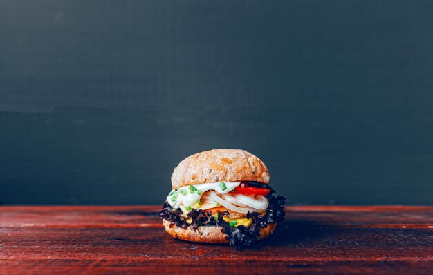 Foto hambúrguer saboroso na tábua de madeira
