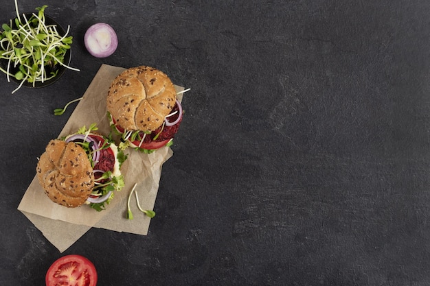 Hambúrguer vegano com costeleta de beterraba e micro verdes na vista superior de fundo preto