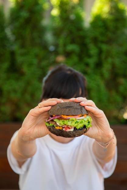 Hambúrguer vegetariano e mão feminina com Vegan com caroço sem glúten com sementes de linho e suco