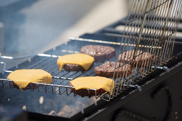 Hambúrgueres com queijo são grelhadosCarne grelhada Um pedaço de carne na fumaça