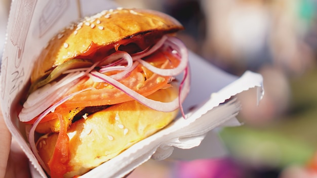 Hambúrgueres de carne servidos em barraca de comida em cozinha aberta, evento do festival internacional de comida de comida de rua