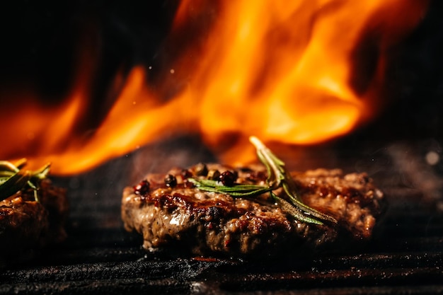 Hambúrgueres de costeleta de carne picada em uma churrasqueira fervendo sobre brasas em brasa. hambúrguer de carne grelhada em aço.